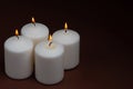 Four whiteÃÂ candlesÃÂ flameÃÂ burningÃÂ onÃÂ dark backgroundÃÂ withÃÂ copyÃÂ space forÃÂ text Royalty Free Stock Photo